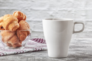 Coffee with cream and freshly baked puffs on a gray background