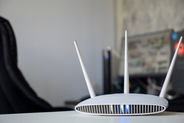 Close up of a wireless router on table at home with desktop computer background
