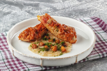 Chicken drumstick ballotin with onion sauce and mushrooms. Stuffed chicken legs