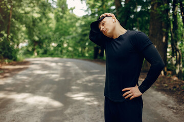 Handsome man in a park. Sportsman in a sportswear. Guy training