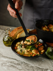 Cooking soup with meatballs cutlets and vegetables in big pan on home kitchen background. Copy space, closeup. Homemade food recipe concept.