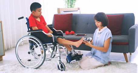 Happy family with mother and disabled son spending time together at home.