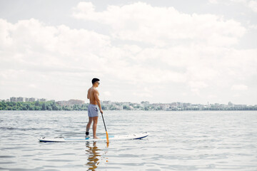 Fototapeta na wymiar Handsome man with a sup. Surfer on a water