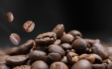 Aroma roasted coffee beans with smoke rising over dark background