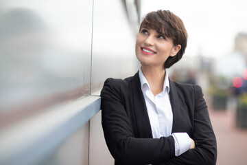 a smiling businesswoman posing outdoors