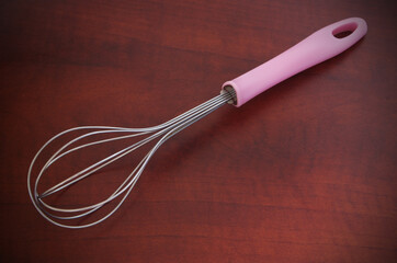 Whisk on wooden background