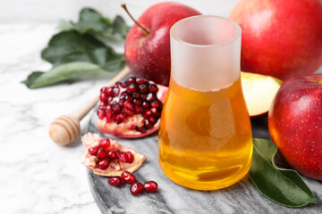 Honey, apples and pomegranate on white marble table. Rosh Hashanah holiday