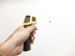 Hand of  mechanic Measuring the temperature of the object With an infrared thermometer to check the temperature