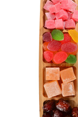 Wooden plate with cashew, marmalade and sweet turkish delight. Isolated on white background. Space for text or design.