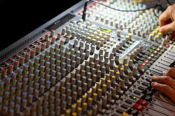 Hands on mixing console in music recording studio