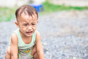 Little naughty Asian child sitting and crying