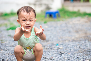 Little naughty Asian child sitting and crying