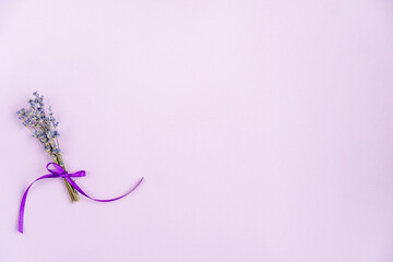 Lavender flowers are arranged on a purple background. The view from the top, flat bed. Minimal...