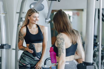 Fototapeta premium attractive girls in sportswear at the gym communicate. sports life and fitness atmosphere.