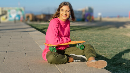 Beautiful young woman with a skateboard © 2Design