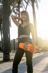 Obraz na płótnie Canvas Closeup of a female teen holding a skateboard outside