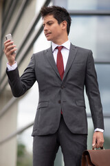 a businessman looking at his cellphone outdoors