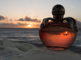 Female perfume in a beautiful bottle on the beach at sunset on Bonaire