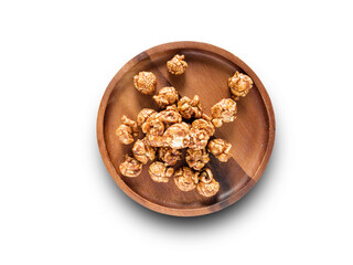 Popcorn caramel on wooden plate isolated