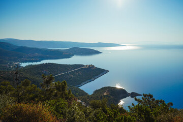 View from the mountain to the beautiful bays of the Mediterranean Sea. Reflection of the setting sun - lunar path. Greece, Halkidiki, Pyrgadikia.