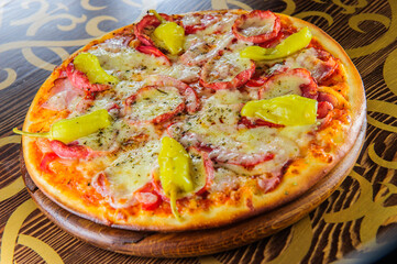 Picture of round pizza on wooden table.