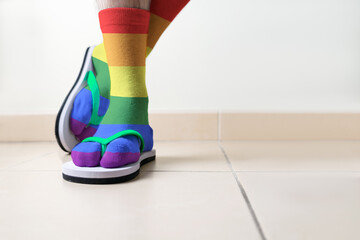 Detail of a man's feet with coloured LGBT socks and beach sandal