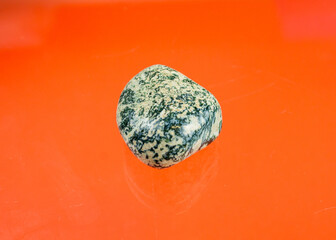 white agate with green inclusions and a smooth surfaceing stone