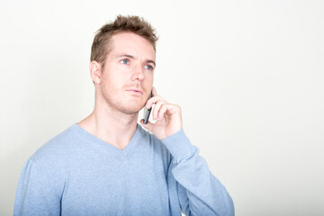 Face of handsome man thinking and talking on the phone