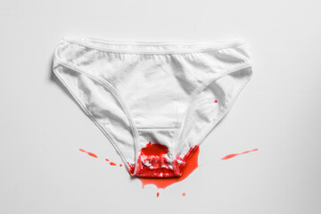 Menstrual fluid and women's underwear on white background, concept photo for women's or feminist blog, ad women's apps