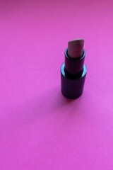 Close up of color nude lipstick on a pink background. Copy space and make up concept