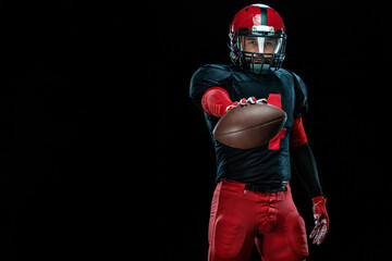Fototapeta na wymiar American football player, athlete sportsman in red helmet on black background. Sport and motivation wallpaper.