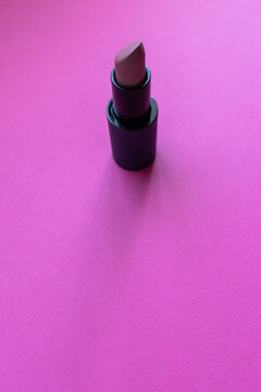 Close up of color nude lipstick on a pink background. Copy space and make up concept