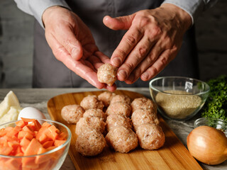 Meatball cutlet cooking by homemade recipe with farm meat, organic vegetables, herbs and spices by man cook hands on kitchen background