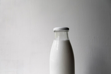 Bottle with milk close-up on a light background, minimalism