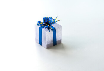 Silver gift box with a blue ribbon and bow on a white background