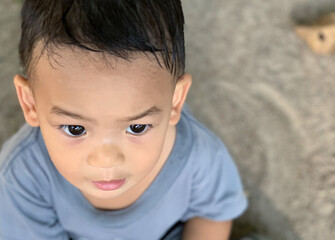 Asian boy portrait closeup playing sand on the ground