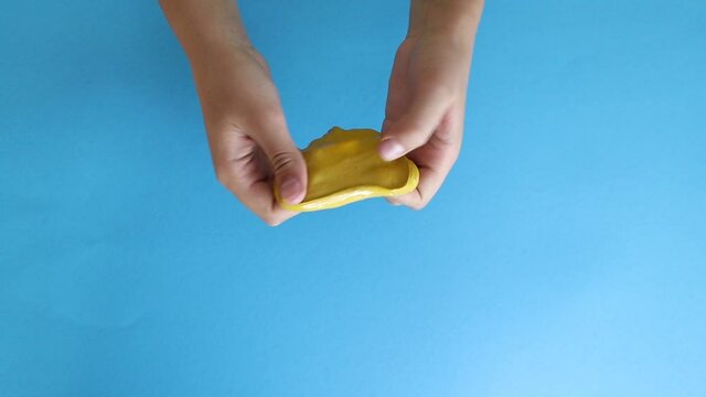 Playing with slime. Child hands playing yellow slime toy.