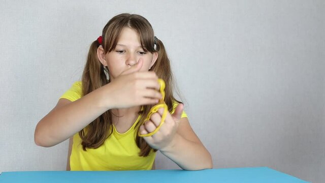 Young girl playing with slime. Stretching yellow slime In the hands of the kid girl. Antistress toys