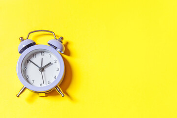 Simply minimal design ringing twin bell vintage classic alarm clock Isolated on yellow background. Rest hours time of life good morning night wake up awake concept Flat lay top view copy space