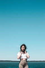 Obraz premium Beautiful happy woman enjoying summer outdoors. Lifestyle concept. Black-haired young woman against the sky.