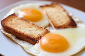Two fried eggs with toast on a plate.