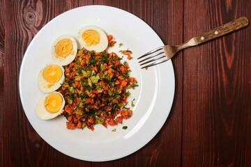 Salad of finely chopped vegetables - carrots, cabbage, cucumbers and boiled chicken eggs.