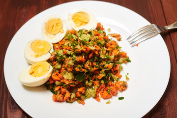 Salad of finely chopped vegetables - carrots, cabbage, cucumbers and boiled chicken eggs.