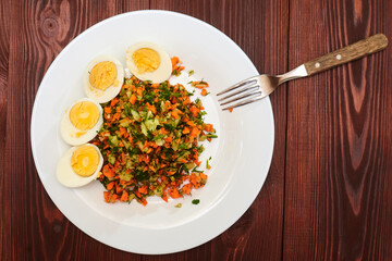 Salad of finely chopped vegetables - carrots, cabbage, cucumbers and boiled chicken eggs.