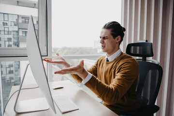 Frustrated angry entrepreneur outraged by pc problem. Furious mad man using computer looking at...