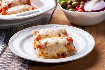 .Pancakes with meat, in tomato sauce and cheese.