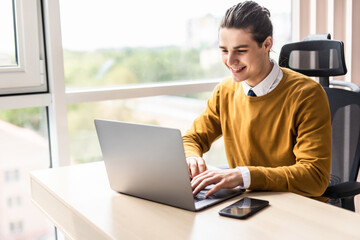 Fototapeta premium Handsome businessman working at modern office on laptop