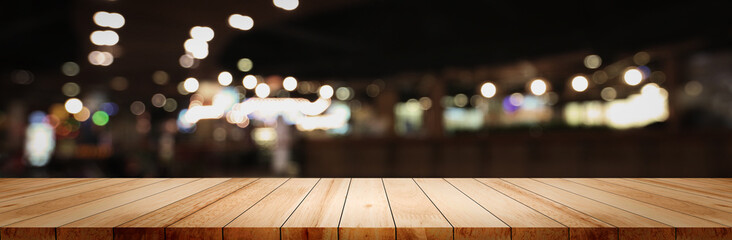 Panoramic empty clean wood counter table top on blur street night cafe background use for pub...
