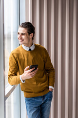 Handsome businessman in formal wear use phone in office