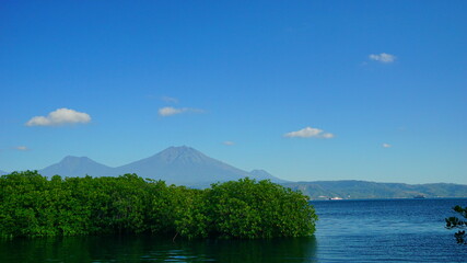A view from Bali strait to Java island. Bali Strait is a stretch of water separating Java and Bali while connecting the Indian Ocean and the Bali Sea. 
